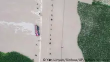 In this aerial photo released by Xinhua News Agency, a truck turned on its side is seen as flood waters flowing across roads and fields in Kaiyuan Town of Shulan in northeastern China's Jilin Province on Friday, Aug. 4, 2023. Northeastern China continued to be pelted by rain on Saturday, as authorities reported more deaths and missing people and evacuated thousands in the wake of Typhoon Doksuri. (Yan Linyun/Xinhua via AP)