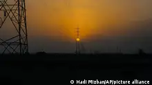 FILE - The sun sets behind the transmission lines of electric power from Iran to Iraq in Basra, Iraq, July 29, 2021. In a statement Wednesday, June 1, 2022, Iraq's Electricity Ministry said the country will face power shortages after crucial energy supplies from Iran were cut over non-payment. (AP Photo/Nabil al-Jurani File)