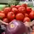 Свежие томаты в блюде среди другие овощей