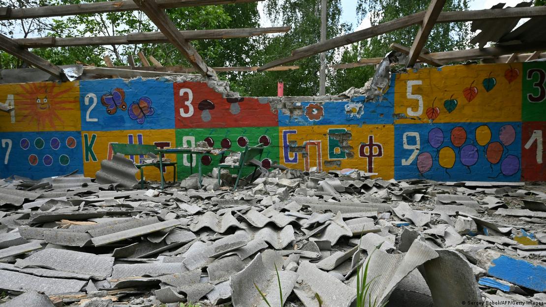 Restos de um muro colorido, pintado com desenhos infantis, do que costumava ser uma creche em Kupiansk, na Ucrânia. Local foi destruído por bombardeio. Além do muro, só sobraram as vigas do telhado. O chão está coberto de destroços. Restos de um muro colorido, pintado com desenhos infantis, do que costumava ser uma creche em Kupiansk, na Ucrânia. Local foi destruído por bombardeio. Além do muro, só sobraram as vigas do telhado. O chão está coberto de destroços.