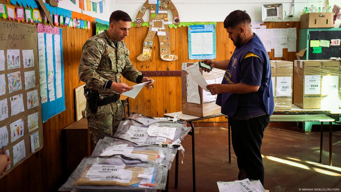 Un soldado y un oficial comprobaron la documentación en una mesa electoral.