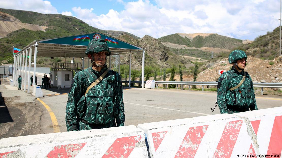 Two soldiers standing behind a road block at a remote crossing