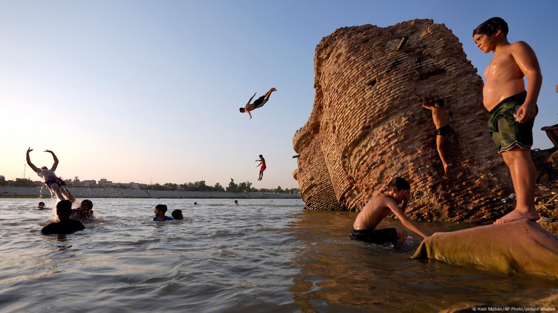 Children and youth swim in the Tigris River to beat the heat in Baghdad, Iraq