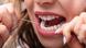 Higiene dental: close-up de boca de mulher passando fio dental nos dentes Higiene dental: close-up de boca de mulher passando fio dental nos dentes
