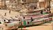 Children play on fishing boats known as "pirogues" on a beach in Dakar