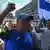 El político, con gorra y camiseta deportiva, gesticula mientras levanta el brazo y grita consignas contra el gobierno de Xiomara Castro.
