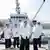 North Korean leader Kim Jong Un standing on a ship with naval officers