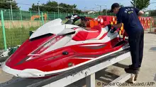 An undated handout photo made available by Korea Coast Guard shows two Coast Guard personel looking at a jet ski in Incheon, after the Coast Guard confirmed it had arrested a Chinese man who attempted to smuggle into the western port city of Incheon last week on the jet ski from China's Shandon. A man who crossed from China to South Korea on a jet ski on a 300 plus kilometre voyage is an asylum seeking human rights activist, his representative told AFP, who has been an outspoken critic of Chinese leader Xi Jinping and was jailed for it.  (Photo by Korea Coast Guard / AFP) / RESTRICTED TO EDITORIAL USE - MANDATORY CREDIT AFP PHOTO / KOREA COAST GUARD - NO MARKETING NO ADVERTISING CAMPAIGNS - DISTRIBUTED AS A SERVICE TO CLIENTS
