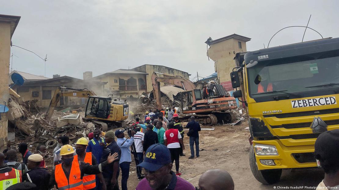 Rescue workers gather at the site of a collapsed building in Abuja, Nigeria. Thursday, Aug. 24, 2023