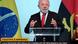 Lula fala em um púlpito. Ao fundo, uma bandeira do Brasil e uma de Angola Lula fala em um púlpito. Ao fundo, uma bandeira do Brasil e uma de Angola