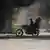 Una moto circula junto al humo de neumáticos ardiendo, durante una manifestación contra la inseguridad en Puerto Príncipe. (Archivo: 14.08.2023)