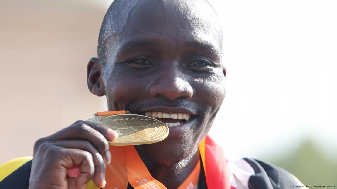 Kiplagat hace el gesto habitual de morder la medalla de oro. Kiplagat hace el gesto habitual de morder la medalla de oro.