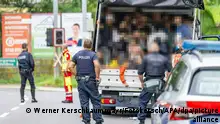 Polizisten stehen bei einer Kontrolle an einem Kleintransporter. Die Beamten entdeckten dabei 53 Personen auf der Ladefläche. Unter den geschleppten Menschen waren auch Kinder. (zu dpa Menschenschmuggel: Lkw mit 53 Menschen in Österreich gestoppt) +++ dpa-Bildfunk +++