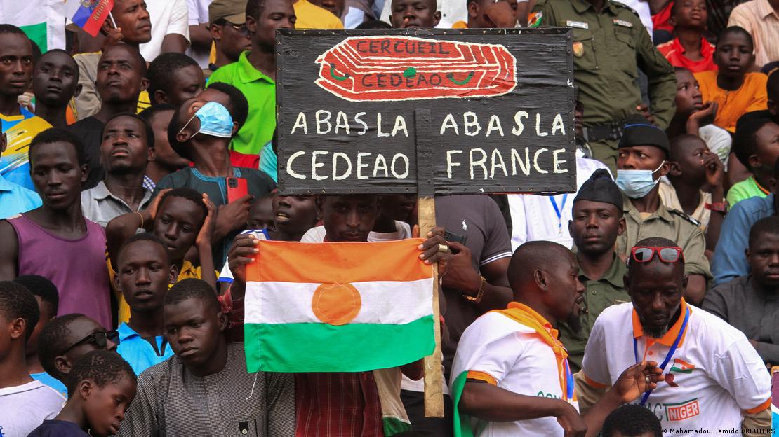 People demonstrating with Nigerien flag and anti-ECOWAS/anti-France poster in Niamey
