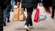 A person holding several shopping bags pictured walking among a crowd of people on a sidewalk in Germany. Symbolic undated stock image. A person holding several shopping bags pictured walking among a crowd of people on a sidewalk in Germany. Symbolic undated stock image.