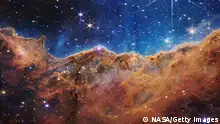 IN SPACE - JULY 12: In this handout photo provided by NASA, a landscape of mountains and valleys speckled with glittering stars is actually the edge of a nearby, young, star-forming region called NGC 3324 in the Carina Nebula, on July 12, 2022 in space. Captured in infrared light by NASA's new James Webb Space Telescope, this image reveals for the first time previously invisible areas of star birth. (Photo by NASA, ESA, CSA, and STScI via Getty Images)