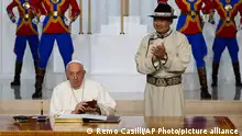 Mongolian President Ukhnaagin Khurelsukh, right, claps his hands at Pope Francis signing the honor book as they meet, Saturday, Sept. 2, 2023, at the State Palace in Sukhbaatar Square in Ulaanbaatar. Pope Francis arrived in Mongolia on Friday morning for a four-day visit to encourage one of the world's smallest and newest Catholic communities. (AP Photo/Remo Casilli, pool)