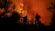 Two firefighters tackling a fire in Greece Two firefighters tackling a fire in Greece