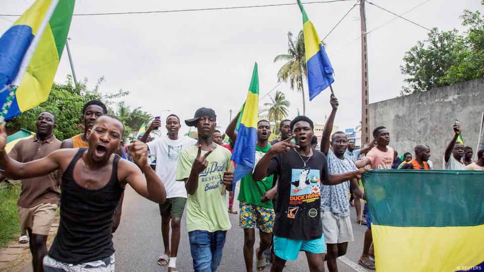 People carrying Gabon's flags celebrate on a street.