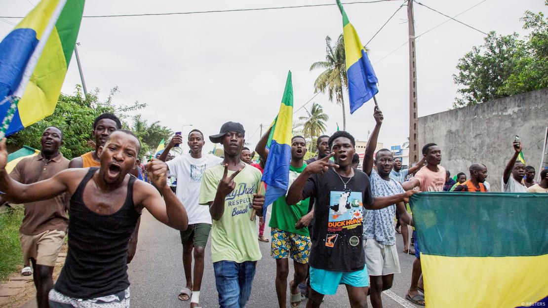 People carrying Gabon's flags celebrate on a street. People carrying Gabon's flags celebrate on a street.