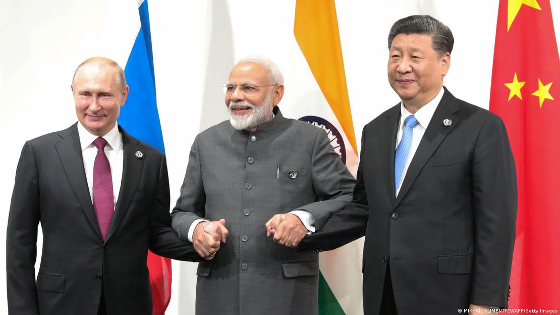 Narendra Modi, no meio, dá as mãos para Vladimir Putin (esquerda) e Xi Jinping (direita)