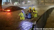 Drainage workers assist a driver stranded due to flooding to a safe place, during heavy rain in Hong Kong, China September 8, 2023. REUTERS/Tyrone Siu TPX IMAGES OF THE DAY 