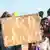 Uma mulher e crianças seguram cartaz durante manifestação, em agosto, contra a França na capital do Níger, Niamey 