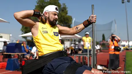  Volodymyr Hera takes part in the shot put final, with a tattoo of a fighter jet on his arm