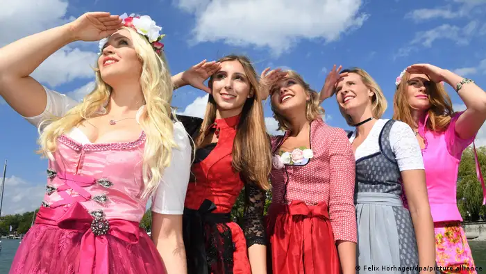 五人向天空行注目礼，三人着粉 造型师预计 2023 年慕尼黑啤酒节将出现大量粉色