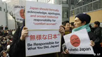 Protesters hold signs during their 1,000th weekly rally to demand an official apology and compensation for wartime sex slaves from the Japanese government near the Japanese Embassy in Seoul, South Korea, Wednesday, Dec. 14, 2011. (AP Photo/Lee Jin-man)