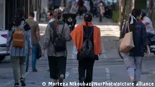 Iranian women without wearing mandatory headscarves, walk along an avenue in downtown Tehran, September 12, 2023. (Photo by Morteza Nikoubazl/NurPhoto)