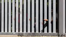 28/05/2023 *** Members of a group of some 30 migrants seeking asylum are seen in Bialowieza, Poland, on Sunday, 28 May 2023 across a wall that Poland has built on its border with Belarus to stop massive migrant pressure. The group has remained stuck at the spot for three days, according to human rights activists. (AP Photo/Agnieszka Sadowska)