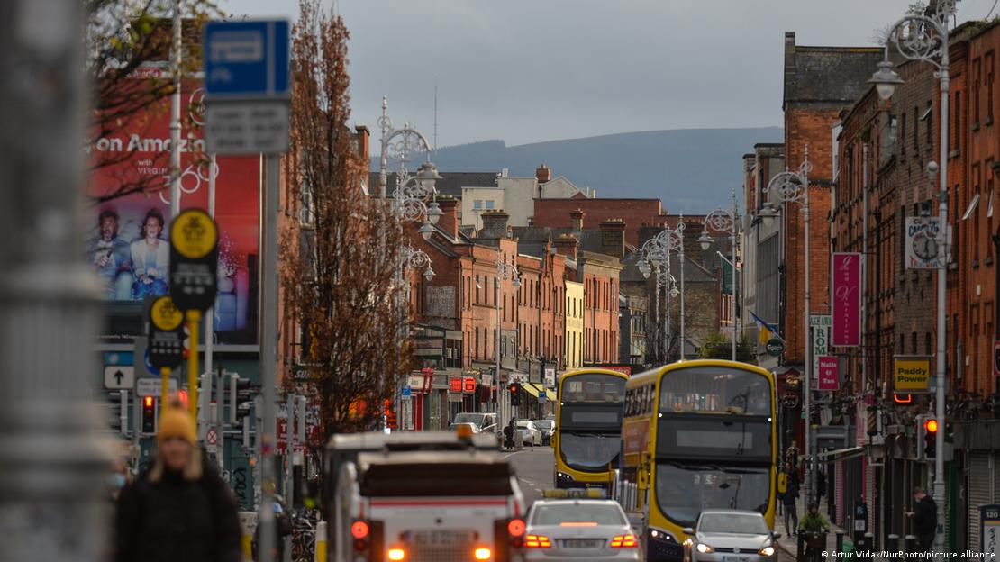 Häuserzeilen, Autos und Busse in Dublin, im Hintergrund ein Berg