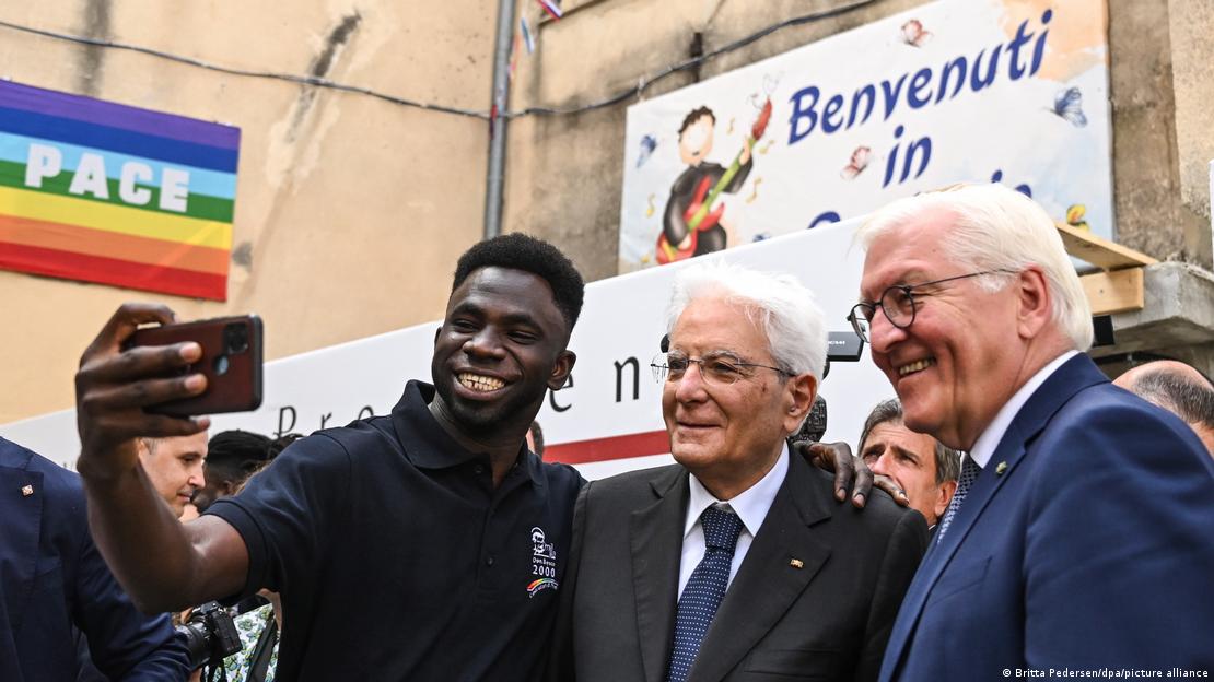 Ο Ιταλός πρόεδρος Sergio Mattarella (κέντρο) και ο Γερμανός πρόεδρος Frank-Walter Steinmeier (δεξιά) ποζάρουν για μια φωτογραφία με έναν πρόσφυγα από την Γκάμπια στη Σικελία, 21 Σεπτεμβρίου 2023.