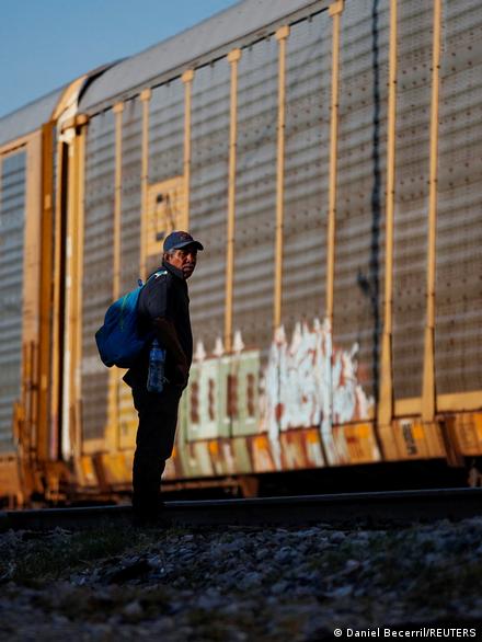 Una persona migrante frente a un tren de mercancías. 