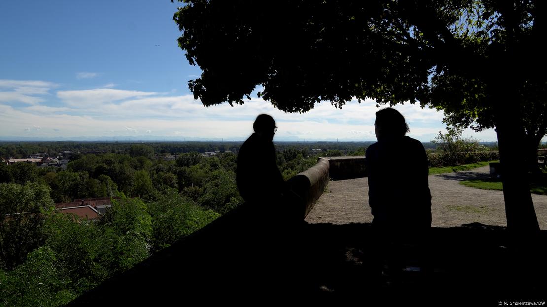 Silhueta de duas pessoas conversando em mirante.