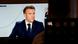 Pessoa observa televisão que transmite entrevista de Macron Pessoa observa televisão que transmite entrevista de Macron