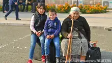 25/09/2023 *** An elderly woman and children sit on bags of belongings as residents gather in central Stepanakert to leave Nagorno-Karabakh, a region inhabited by ethnic Armenians, September 25, 2023. REUTERS/David Ghahramanyan