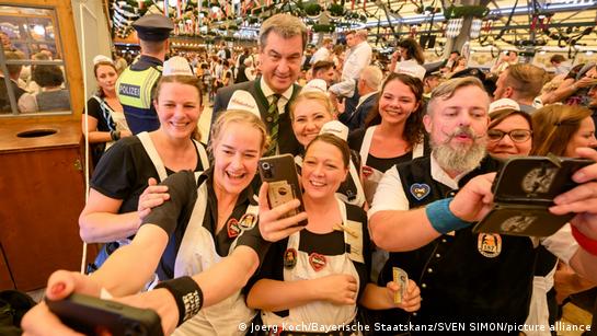 Markus Söder posing with waiters at the Oktoberfest opening 2023