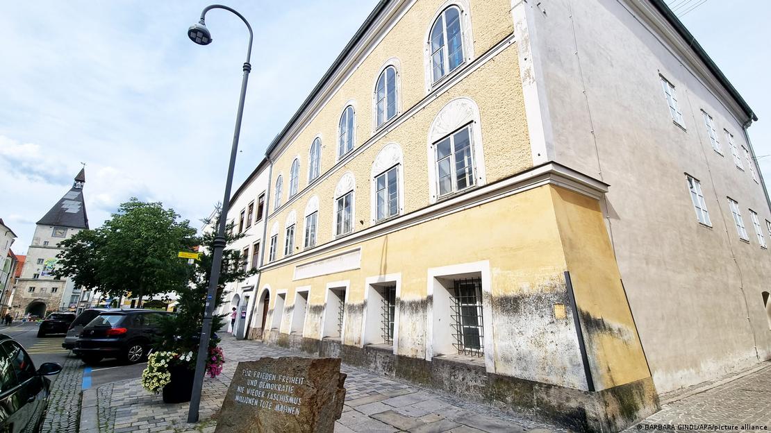 Braunau am Inn'de köşe başında yer alan eski ve bakımsız bir bina görülüyor. Hitler'in doğduğu evin dönüştürülmeden önceki halini gösteren fotoğrafta, binanın önünde anıt taşı, kaldırım ve sokak lambası yer alıyor; cephede çok sayıda pencere ve yıpranmış duvar bölümleri dikkat çekiyor Braunau am Inn'de köşe başında yer alan eski ve bakımsız bir bina görülüyor. Hitler'in doğduğu evin dönüştürülmeden önceki halini gösteren fotoğrafta, binanın önünde anıt taşı, kaldırım ve sokak lambası yer alıyor; cephede çok sayıda pencere ve yıpranmış duvar bölümleri dikkat çekiyor