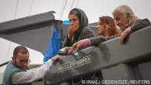 Refugees from Nagorno-Karabakh region sit in the back of a truck upon arrival in the border village of Kornidzor, Armenia, September 26, 2023. REUTERS/Irakli Gedenidze