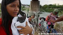 26.09.2023****A migrant from Venezuela holds her cat named Grey that she picked up along the route, after crossing the Rio Grande and making her way through the razor wire into the United States in Eagle Pass, Texas, U.S., September 26, 2023. REUTERS/Brian Snyder TPX IMAGES OF THE DAY 