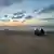 People sit on the beach in Gaza watching the sunset