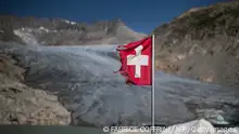 A photograph taken on August 24, 2023 above Gletsch, in the Alps shows a frayed Swiss flag next to insulating foam covering a part of the Rhone Glacier to prevent it from melting. A leading Swiss glaciologist warned on August 16, 2023 that 2023 was looking not good for the country's glaciers, a year after they suffered a record melt. Still more than a month to go in the melting season. How are Swiss glaciers doing at the moment? Not good! glaciology professor Matthias Huss, head of Glacier Monitoring in Switzerland (GLAMOS), said on the platform X, formerly known as Twitter. (Photo by Fabrice COFFRINI / AFP) (Photo by FABRICE COFFRINI/AFP via Getty Images)