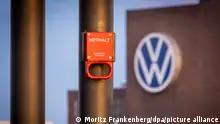 Ein Schalter mit der Aufschrift «Nothalt» ist am Morgen vor einem Logo am Volkswagen Stammwerk zu sehen. Volkswagen hat nach eigenen Angaben die IT-Störung behoben, die die Produktion in mehreren Werken seit Mittwoch lahmgelegt hatte. Die Produktion fahre nun wieder hoch.
