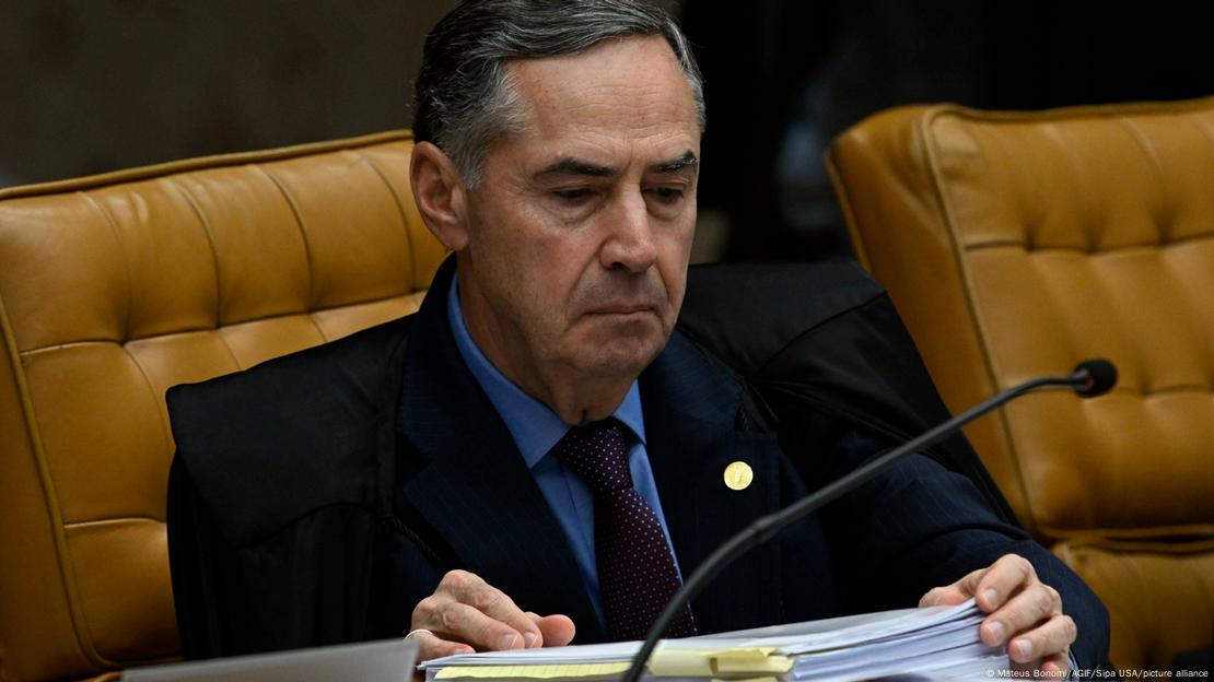 Ministro Luís Roberto Barroso manuseia pilha de papeis Ministro Luís Roberto Barroso manuseia pilha de papeis
