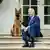 US President Joe Biden holds collar of his pet German Shepherd while sitting on steps of Rose Garden of the White House