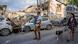 People walk past the rubble of a building in Tel Aviv a day after it was hit by a rocket fired from the Gaza Strip.