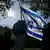 Foto simbólica de una persona que sostiene una bandera de Israel en una imagen de archivo.