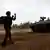 An Israeli soldier directs an armoured personnel carrier at the Israeli side of the Gaza border.